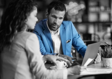 Woman and man looking at laptop in cafe